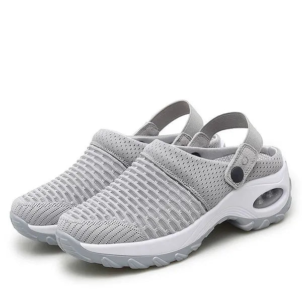 Pair of light gray mesh clogs with white air-cushion soles and snap-button heel straps, shown on a plain white background.