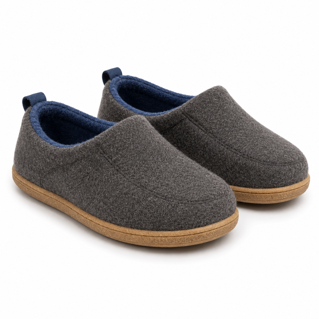Pair of charcoal gray felt slippers with blue lining and blue heel loops, shown at an angle.