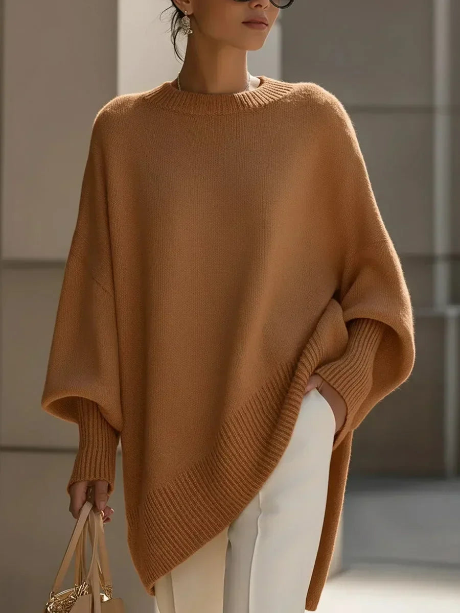 Model wearing the camel brown oversized sweater with ribbed cuffs and slanted hem, white pants, tan bag 12