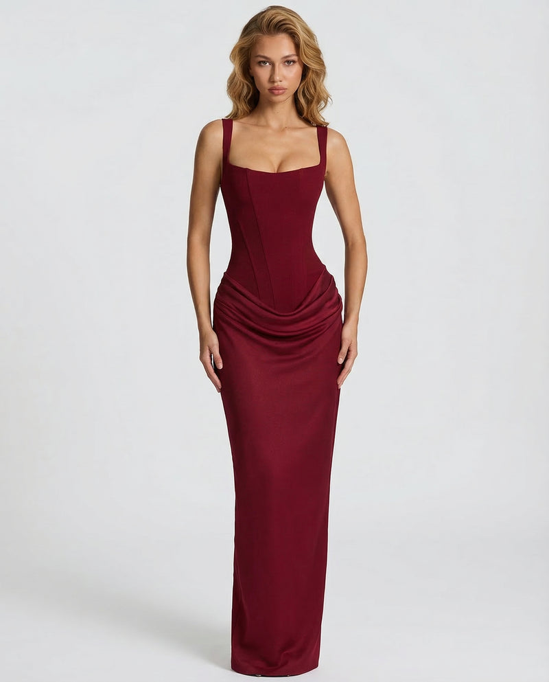 Burgundy maxi dress front view with corset seaming and ruched hip drape.