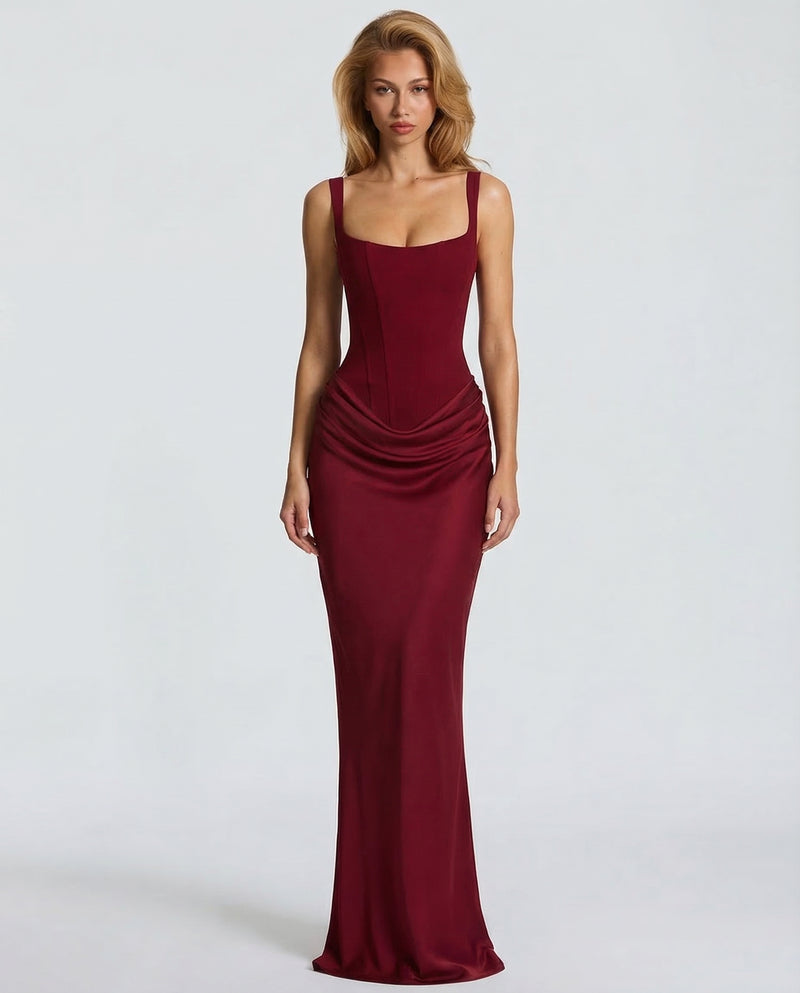 Burgundy satin-finish maxi dress with a square-neck corset bodice and draped hip detail, front view.