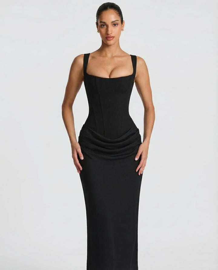 Black maxi dress detail with a seamed corset bodice and gathered drape at the hip.