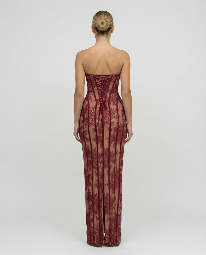 Back view of the red lace maxi dress showing the lace-up corset back, strapless cut and a slit at the hem.