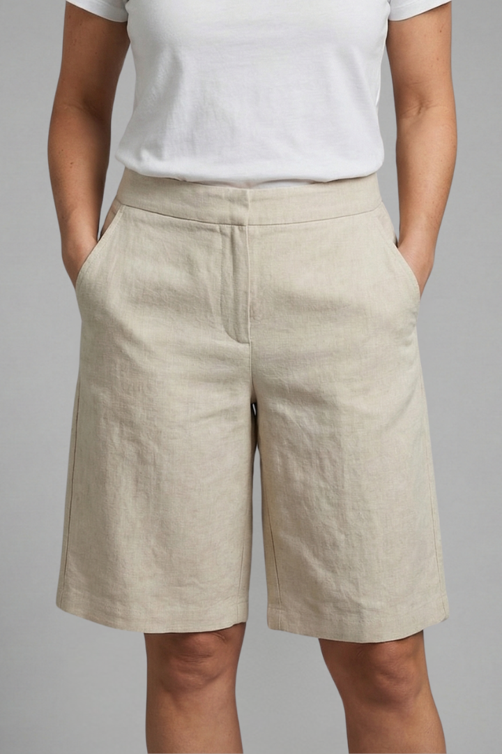 Beige high-waisted linen shorts with side pockets, front close-up.