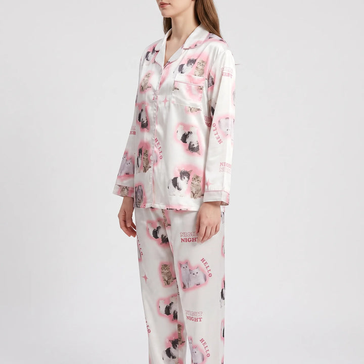 Three-quarter side view of a model in the pink kitten-print satin pajama set, showing the chest pocket and sleeve print. 4