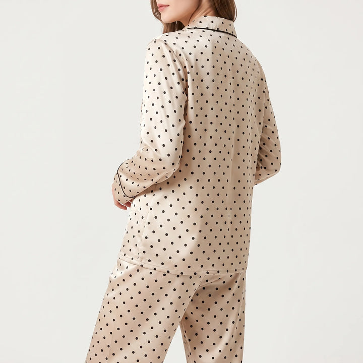 Back view of the polka dot pajama shirt on a model, showing the all-over dot print and black-piped cuff. 3