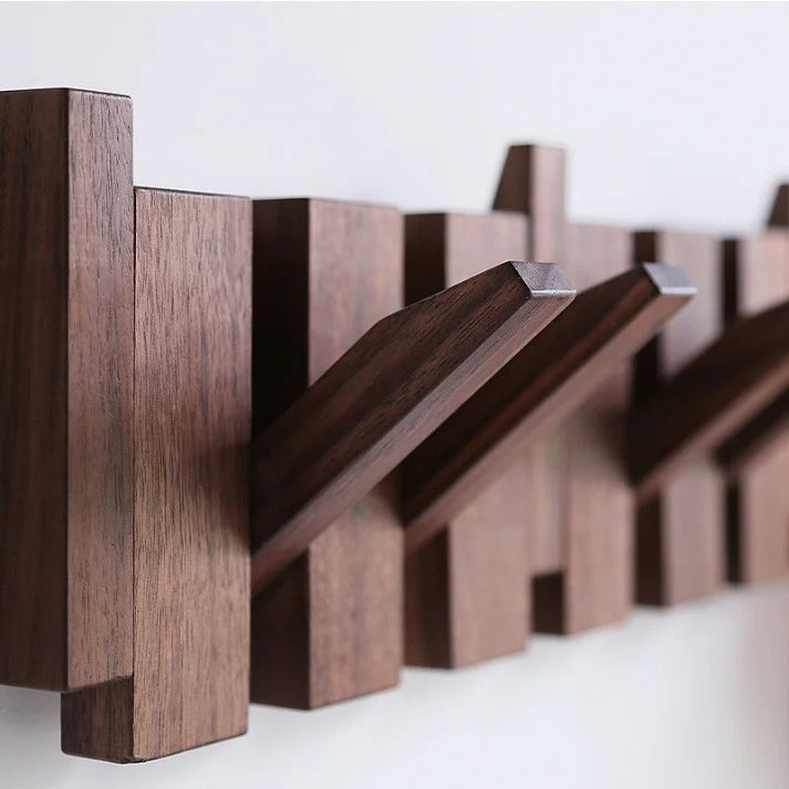 Close-up of several walnut folding hooks pulled out at an angle, showing the wood grain and stepped block design. 7