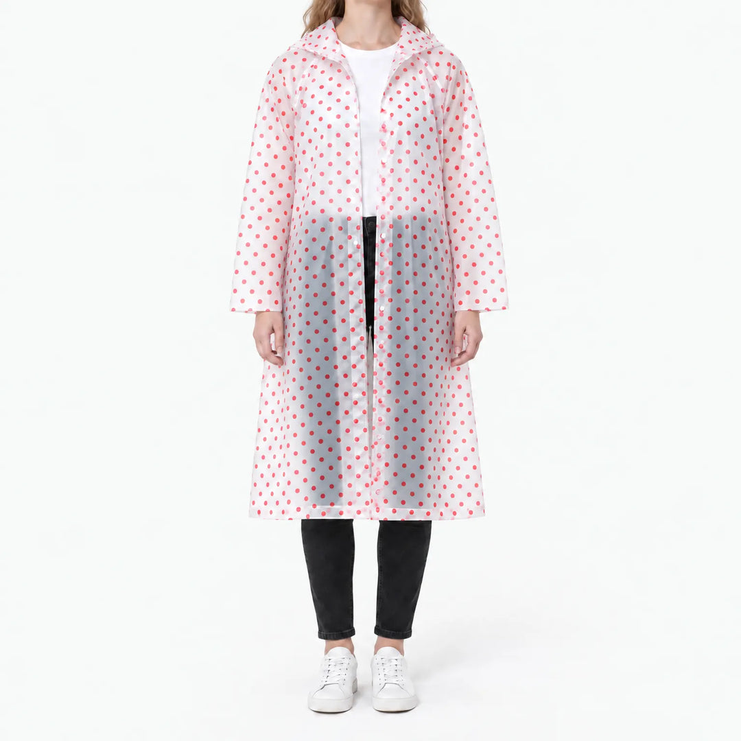 Front view of a woman in a translucent long raincoat with red polka dots, snap front partly open over a white tee and black jeans. 10
