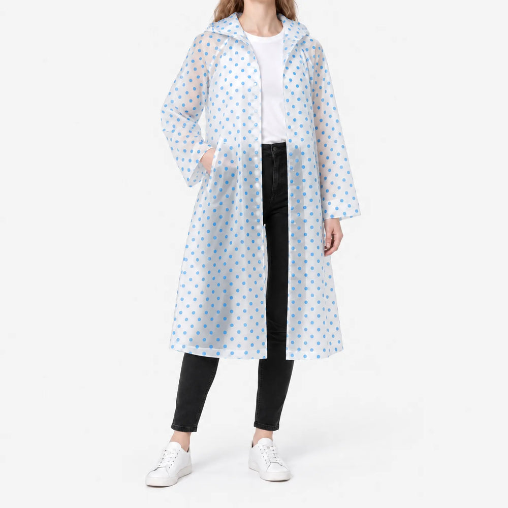 Woman in a translucent long raincoat with blue polka dots, hood down, one hand in a pocket, snap front open over a white tee. 2