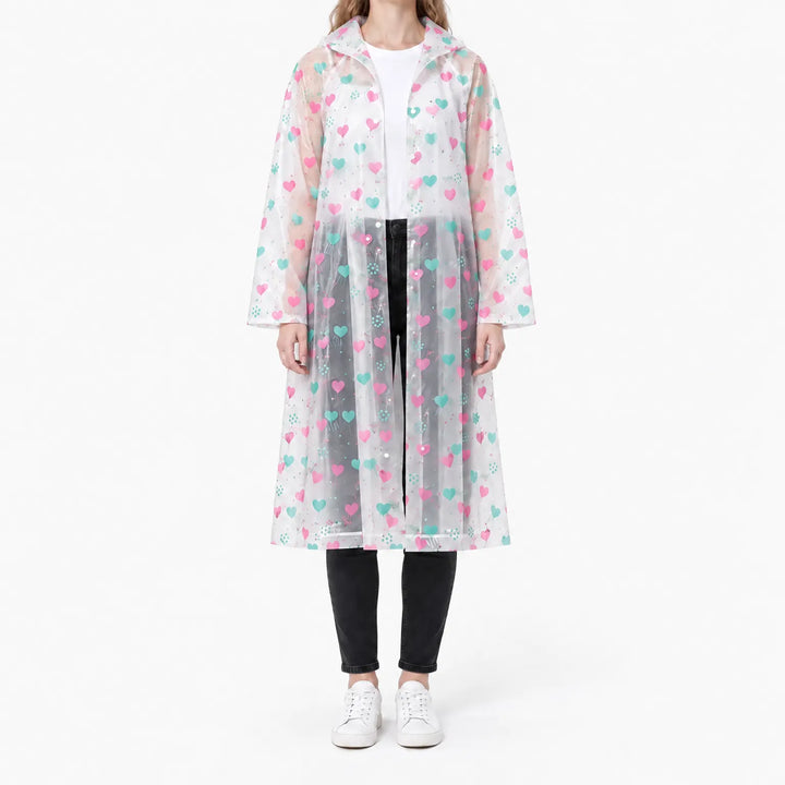 Woman in a translucent long hooded raincoat with pink and teal hearts, snaps partly fastened over a white tee and black jeans. 7