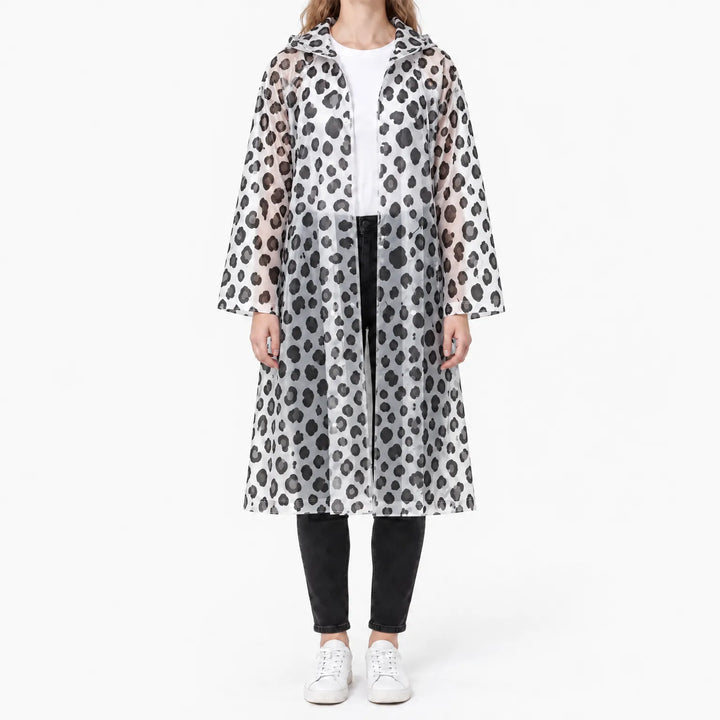 Front view of a woman in a translucent hooded raincoat with black and gray leopard-style spots, worn open over a white tee and black jeans. 8