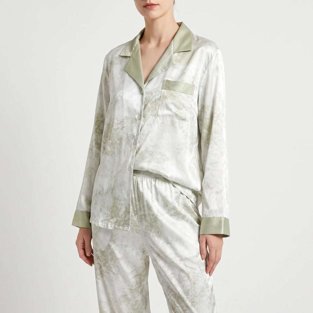Front three-quarter view of the buttoned pajama shirt with green notched collar, chest pocket and green cuffs over matching pants. 2