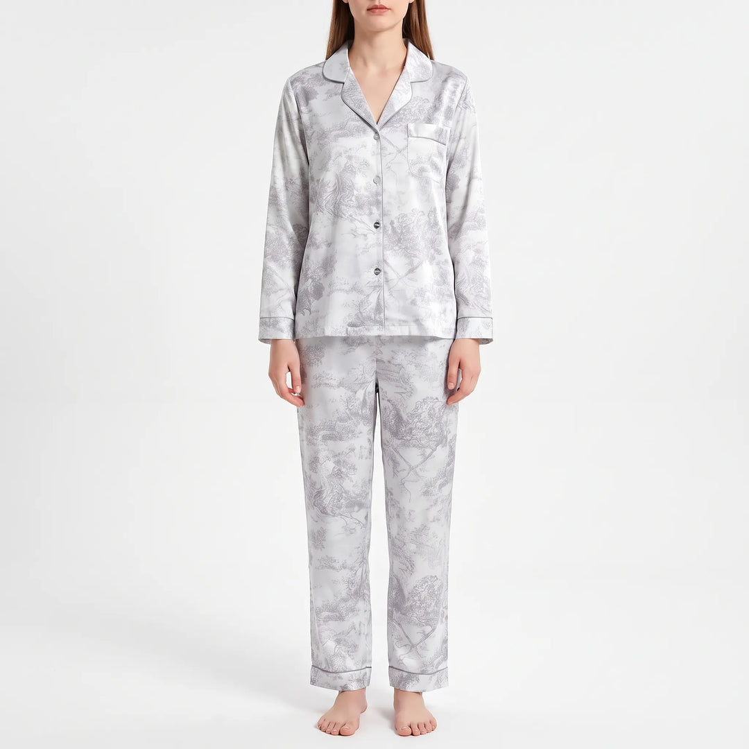 Model standing in a gray and white pastoral scene print pajama set with piped edges and a chest pocket. 6