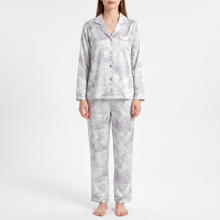 Model standing in a gray and white pastoral scene print pajama set with piped edges and a chest pocket. 6