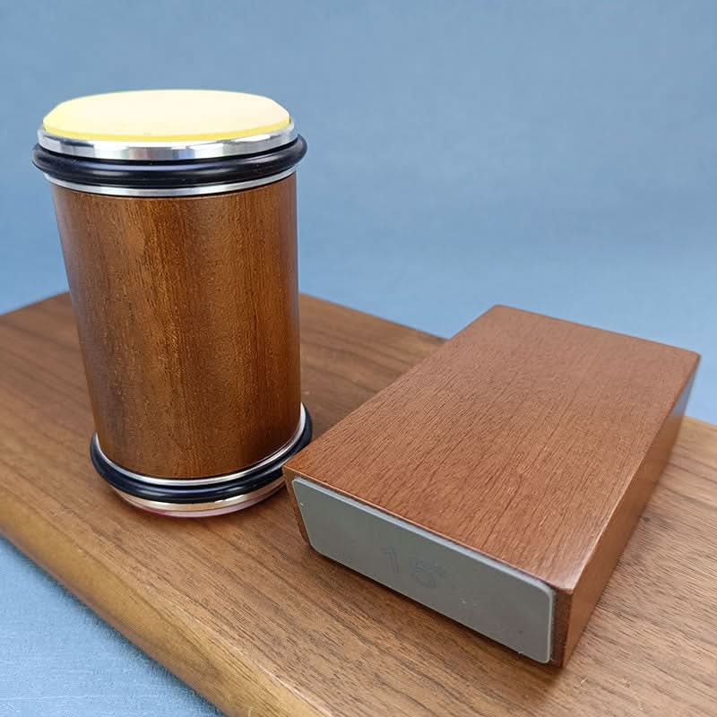 Wooden roller with a yellow-toned end disc standing next to the angle block on a wooden board 5