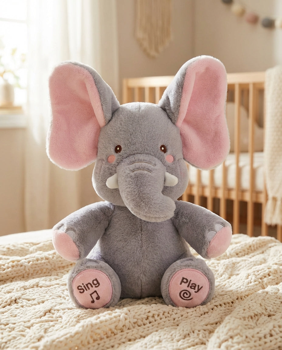 PeekaBuddy The Giggle Elephant Interactive Peekaboo Plush in grey and pink on a cream knit blanket.