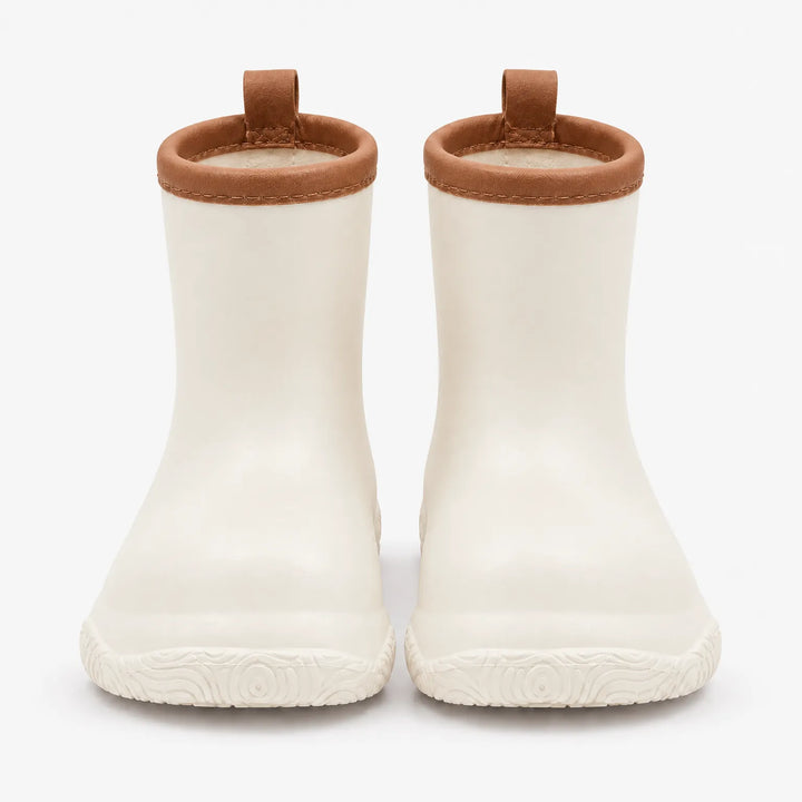 Front view of cream white rain boots with brown collars and pull loops, showing the swirl-patterned soles. 10