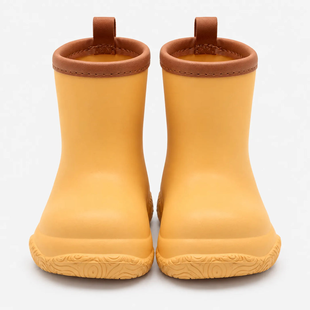 Front view of golden yellow rain boots with brown collars and pull loops, showing the swirl-patterned soles. 11