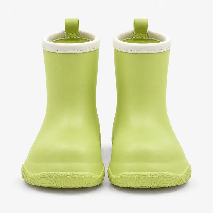 Front view of light green rain boots with cream collars and green pull loops, showing the swirl-patterned soles. 7