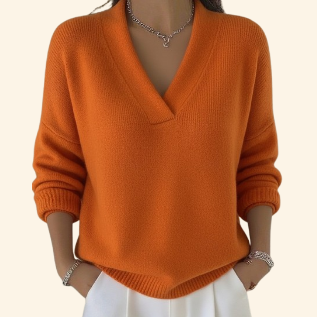 Model wearing the knit V-neck sweater in bright orange with ribbed cuffs and hem.