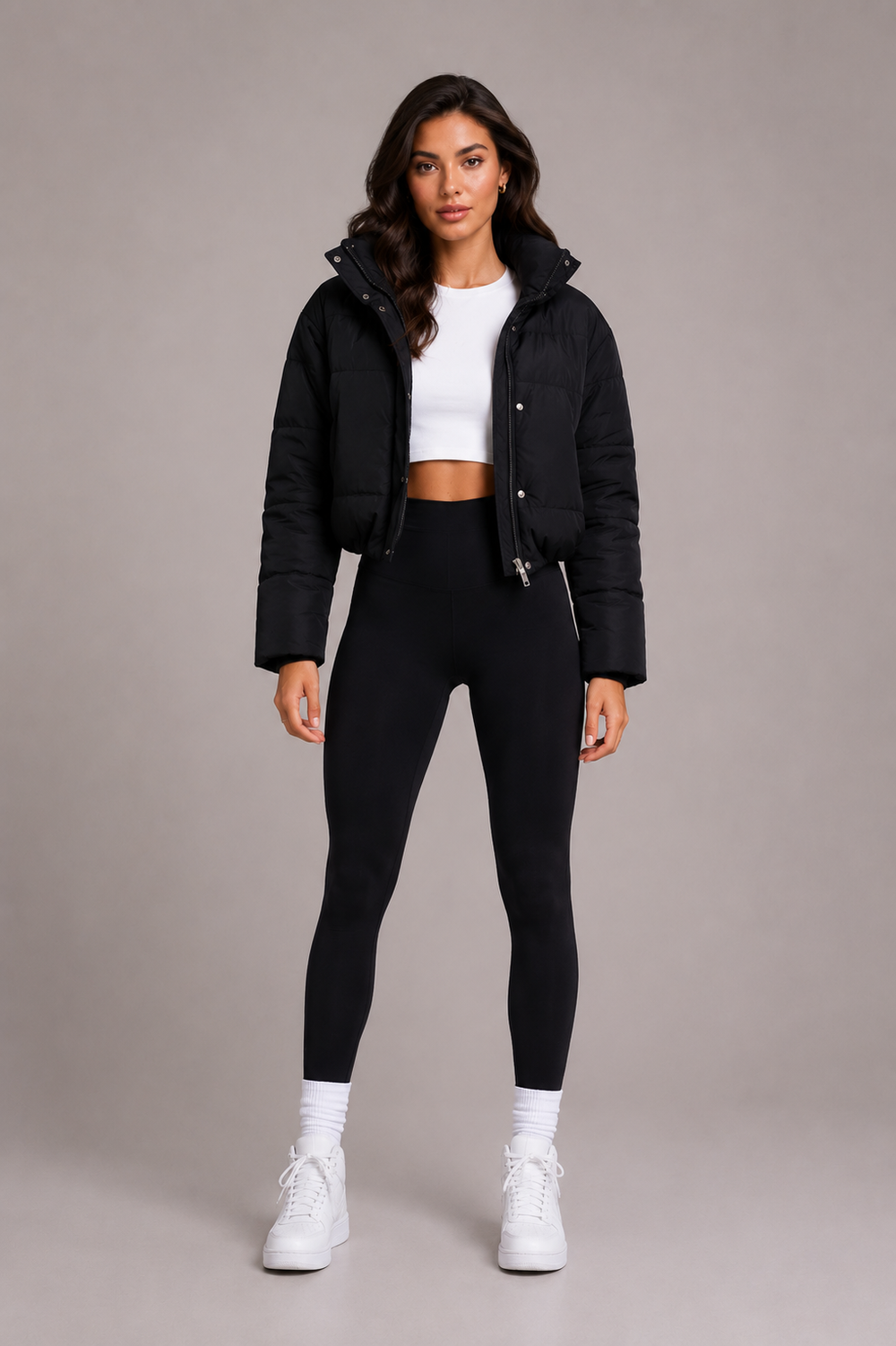 Black cropped puffer jacket front view worn with a white crop top, black leggings and white sneakers.