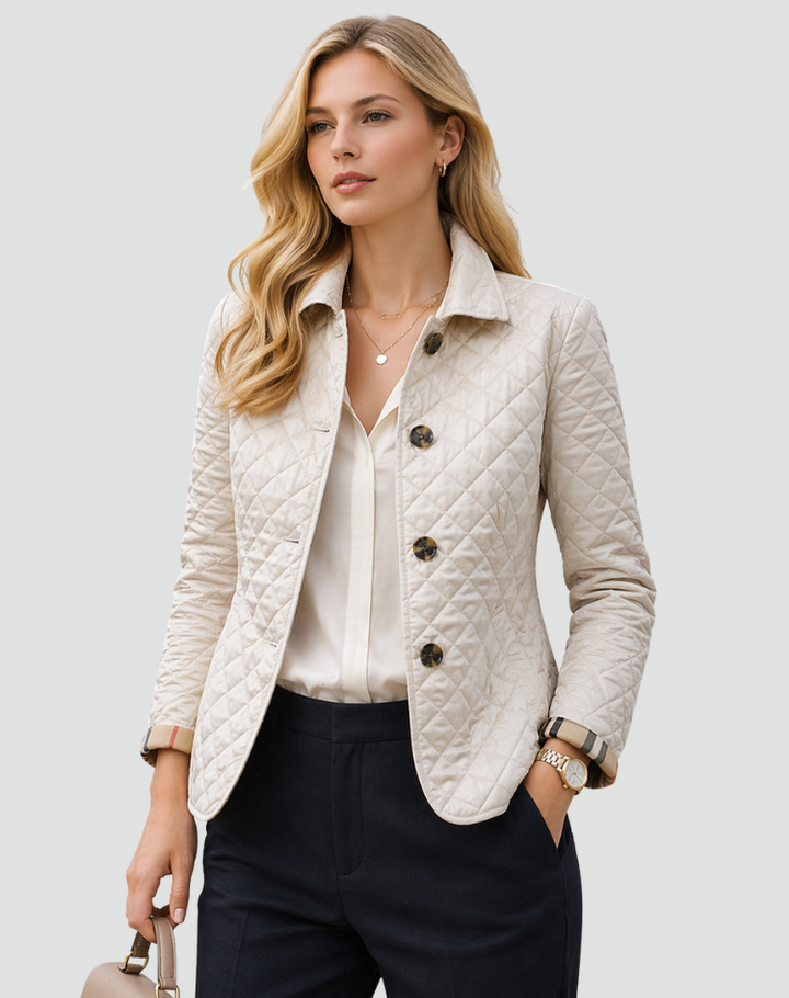 Cream quilted jacket with tortoiseshell-style buttons, styled with a white blouse and navy trousers.