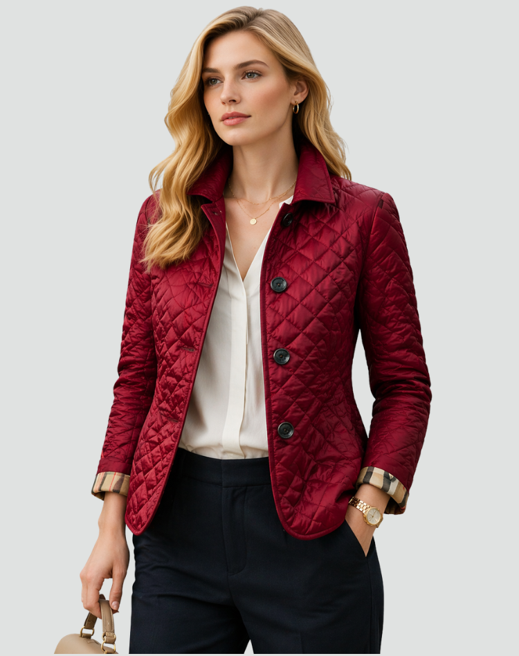 Burgundy quilted jacket with dark buttons, styled with a white blouse and navy trousers.