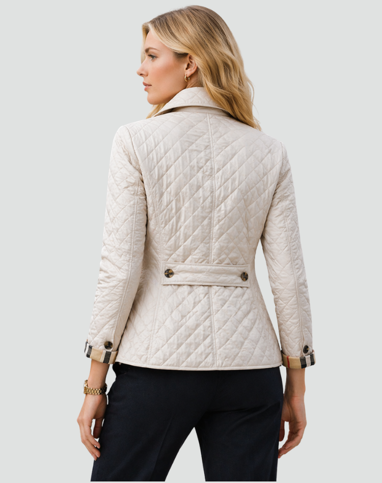 Back view of the cream quilted jacket showing diamond stitching, a buttoned waist strap and checked turned-back cuffs.