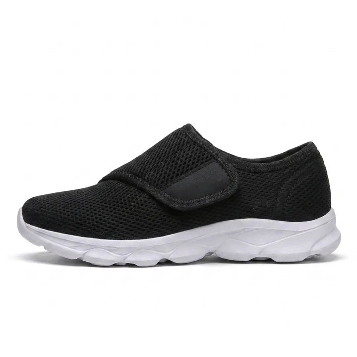 Side view of a black mesh shoe with a white sole and a single hook-and-loop strap 19