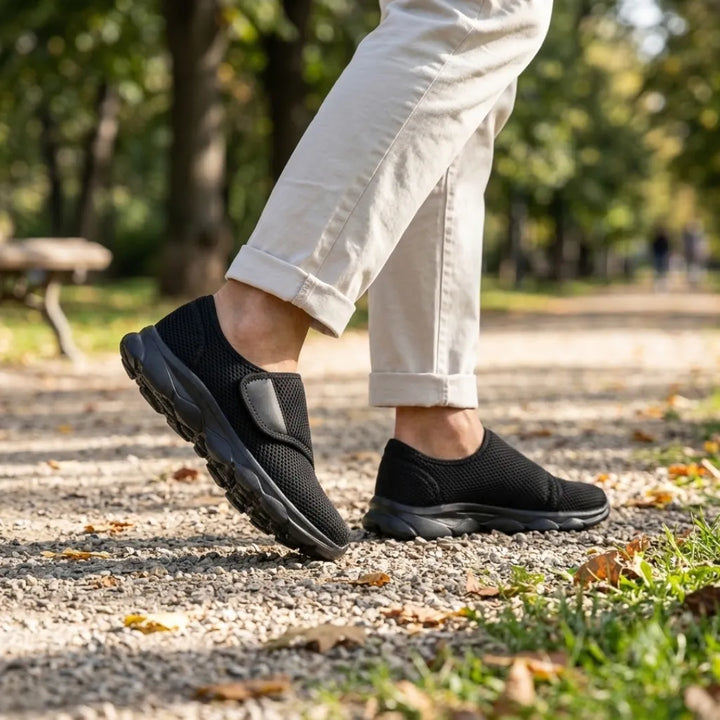 Person walking on a park path in all-black mesh strap shoes and rolled beige pants 11