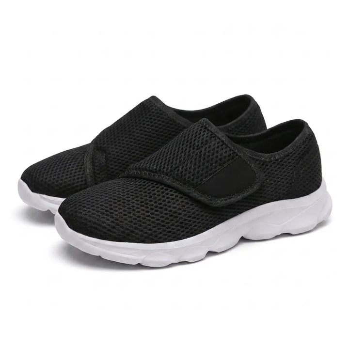 Pair of black mesh walking shoes with white soles and wide hook-and-loop straps, seen at an angle 25
