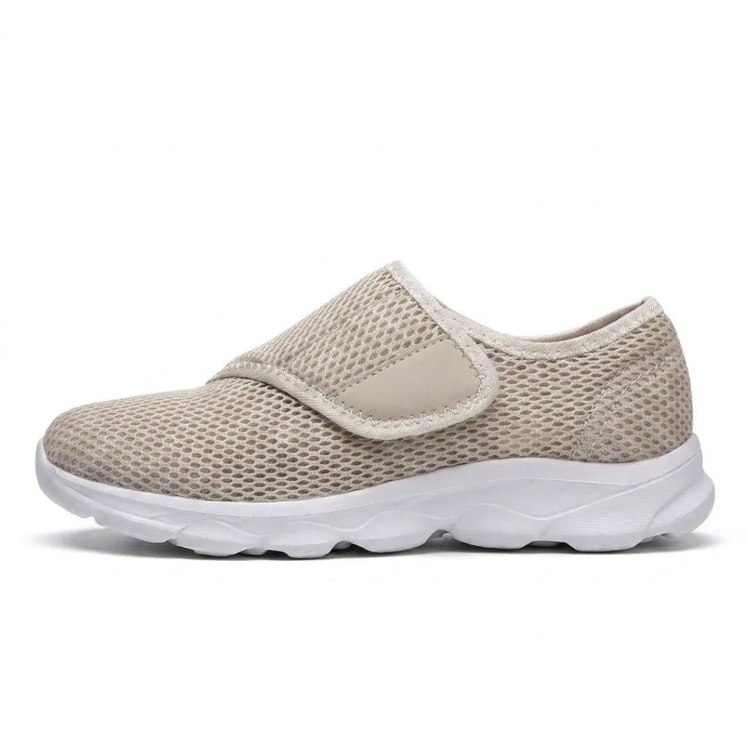 Side view of a beige mesh shoe with white sole and wide hook-and-loop strap across the instep 28
