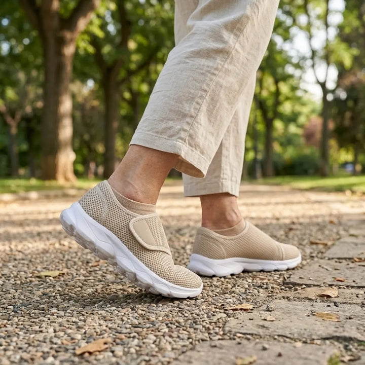 Person walking on a gravel park path in beige mesh strap shoes, beige socks and linen pants 29