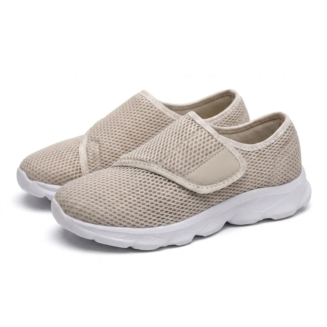 Pair of beige mesh walking shoes with white soles and wide hook-and-loop straps, seen at an angle 34