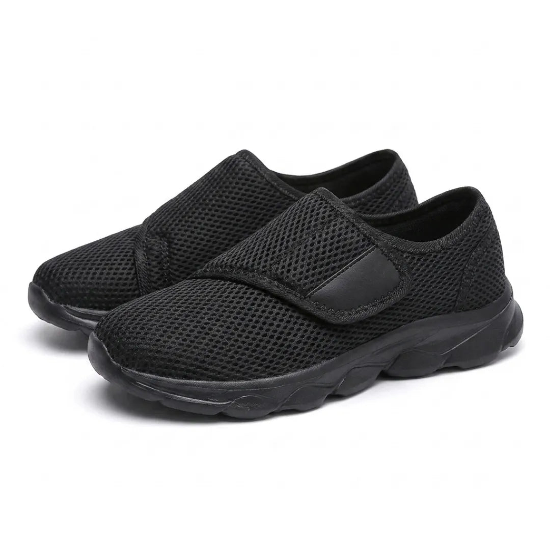 Pair of all-black mesh shoes with hook-and-loop straps, shown at an angle 16