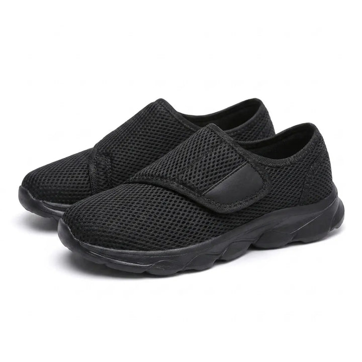 Pair of all-black mesh shoes with hook-and-loop straps, shown at an angle 16