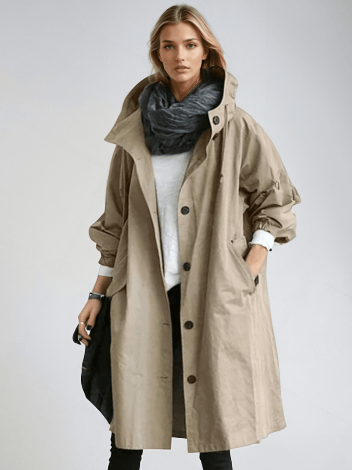 Model in the beige hooded coat, buttoned with a high collar over a white top and charcoal scarf 3