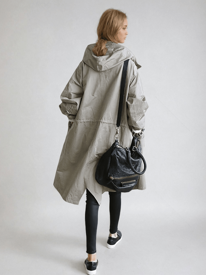 Back view of the gray hooded coat, showing the drawstring waist seam, with a black shoulder bag 4
