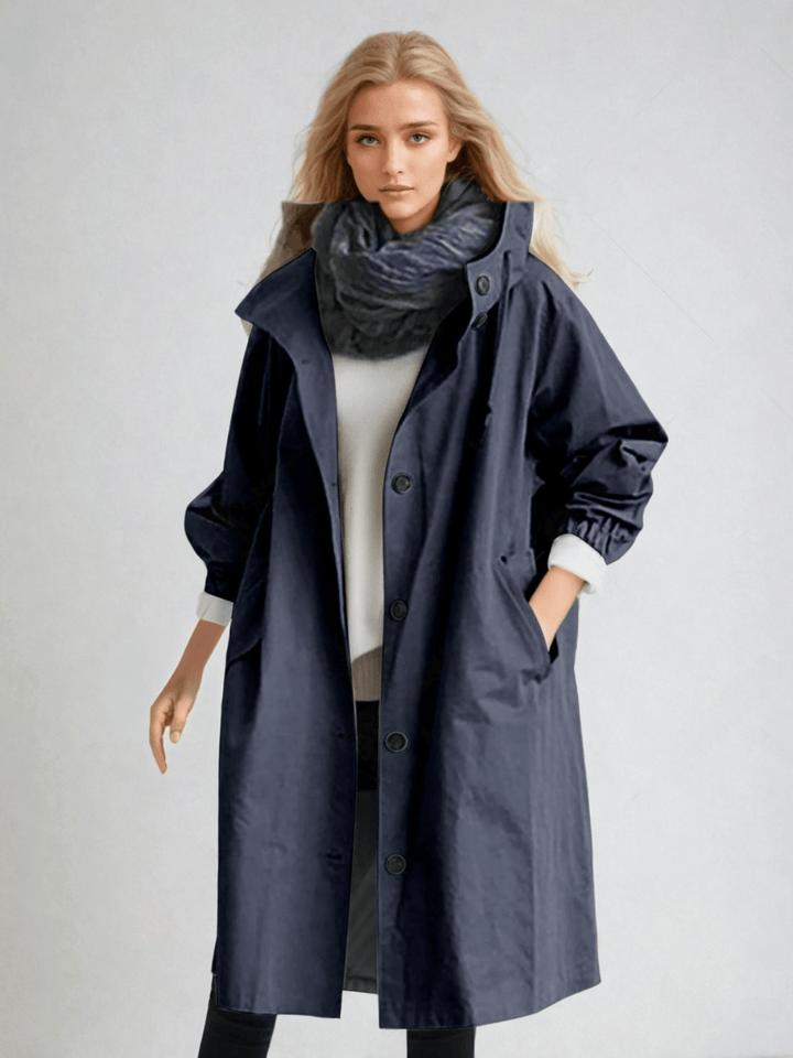 Model in the navy blue hooded coat, buttoned with a high collar, dark scarf and white sweater 7
