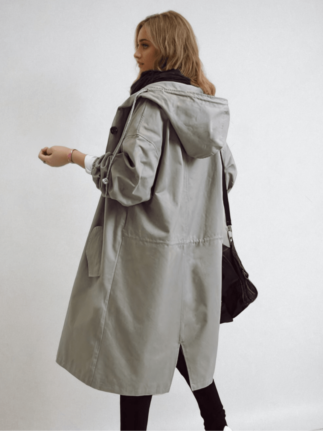 Side-back view of the light gray hooded coat showing the hood, drawstring waist, sleeve ties and back vent 8