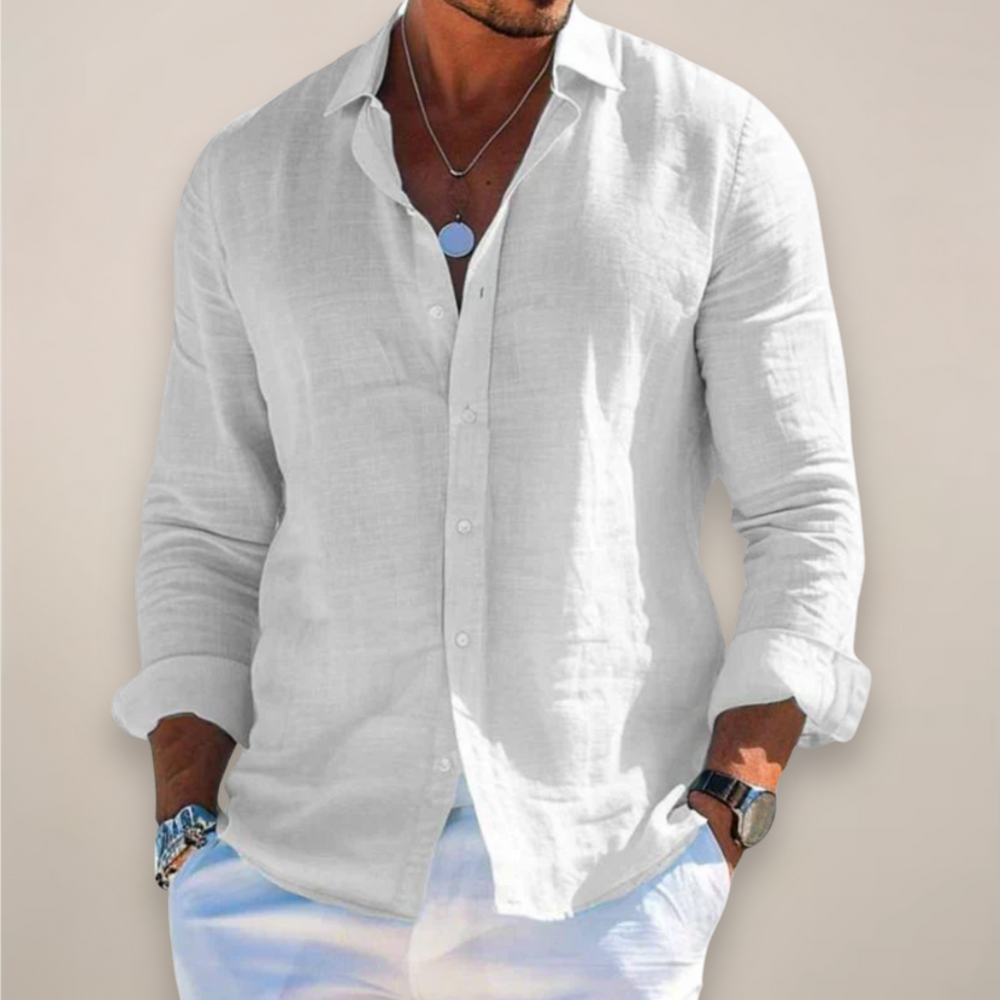Man wearing the white long-sleeved button-front shirt with rolled sleeves and a pendant necklace.