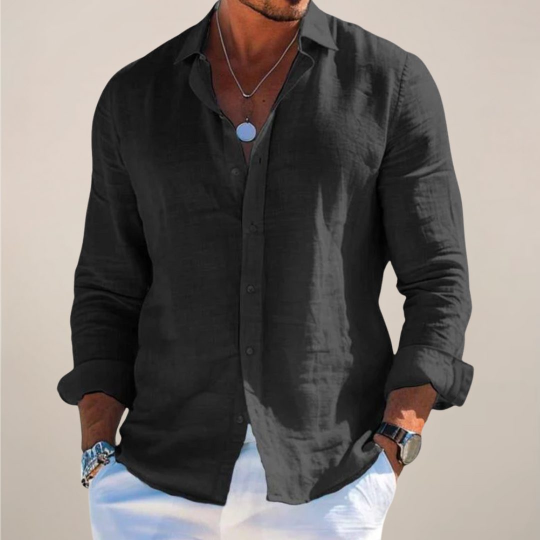 Man wearing the black long-sleeved button-front shirt with rolled sleeves and white pants.