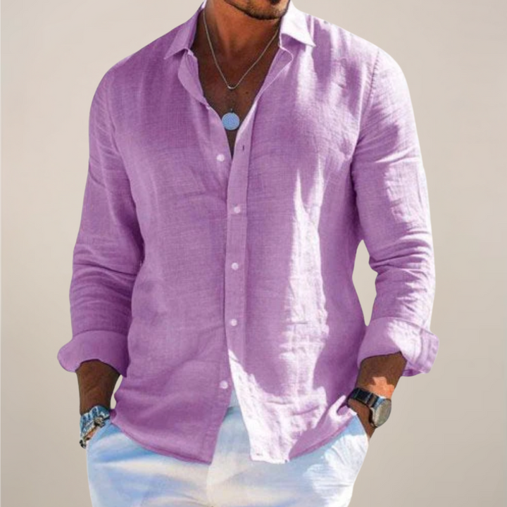 Man wearing the lilac purple long-sleeved button-front shirt with rolled sleeves, worn open at the collar over white pants.