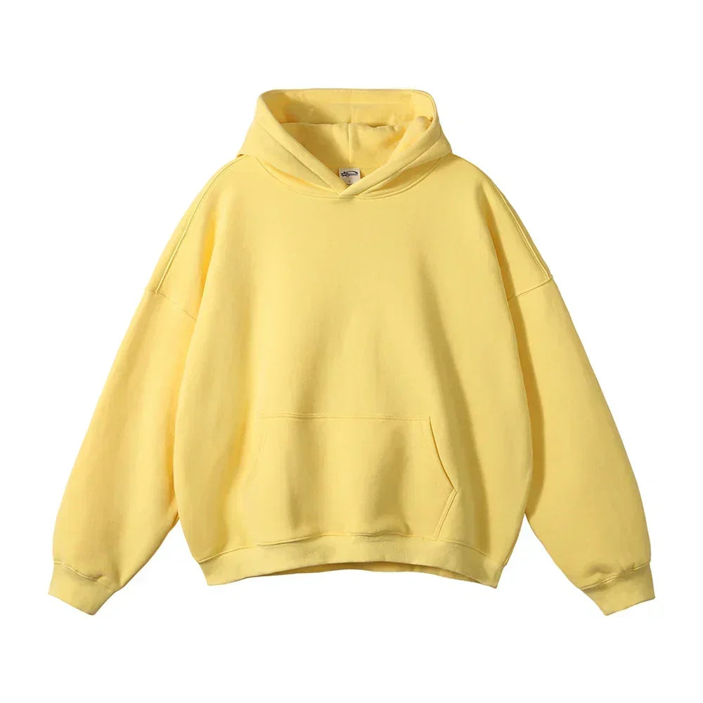 Front view of the hoodie in pale yellow, laid flat, with a kangaroo pocket, ribbed cuffs and relaxed shape.