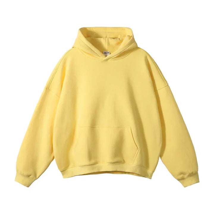 Front view of the hoodie in pale yellow, laid flat, with a kangaroo pocket, ribbed cuffs and relaxed shape.