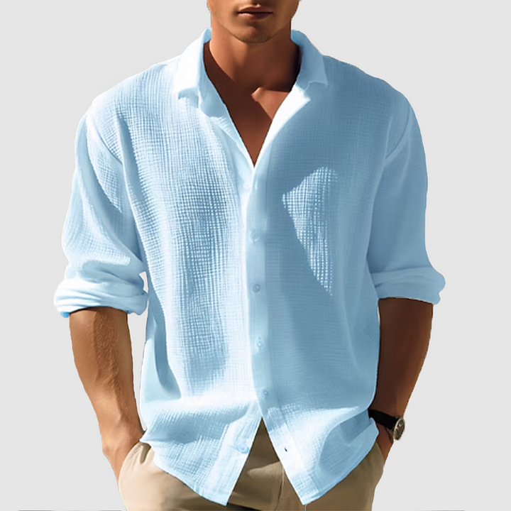 Man wearing the textured shirt in light sky blue, sleeves rolled, hands in khaki pants pockets 1