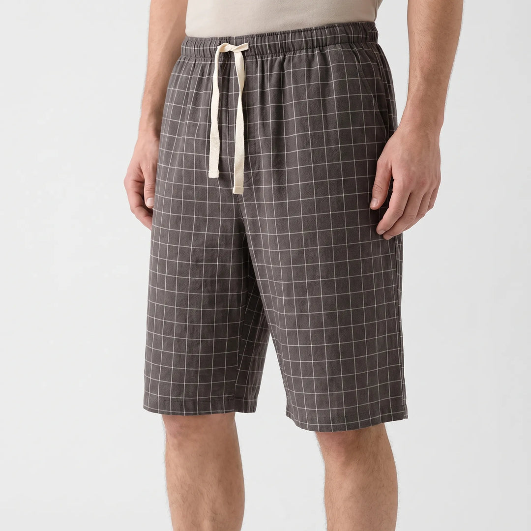 Three-quarter side view of gray check shorts with cream drawstring, worn with a beige tee on a model. 4