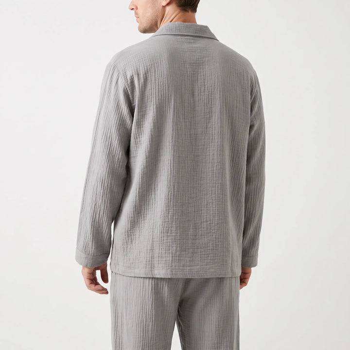 Back view of the gray crinkle-textured pajama shirt worn by a model, showing the plain back and long sleeves with cuffs. 3