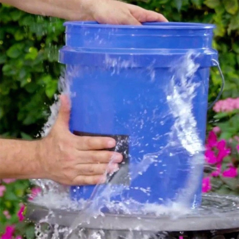 Hands press a black patch onto a blue bucket with water spraying around the repaired spot.