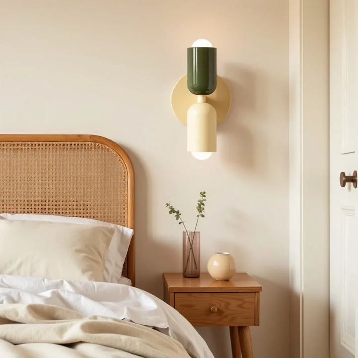 Retro wall lamp in dark green and cream beside a rattan headboard